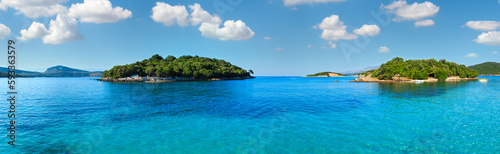 Beautiful Ionian Sea with clear turquoise water and morning summer coast. View from Ksamil beach, Albania. Panorama.