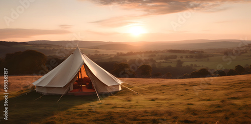 Set up on a field, with a tent in the background and a gorgeous sunset as the backdrop, witness the breathtaking beauty of nature. The ideal nature wallpaper is this scenic vista. © bharath