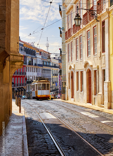 Old retro tram at street Lisbon in Portugal. Sunny summer with moving touristic on the road