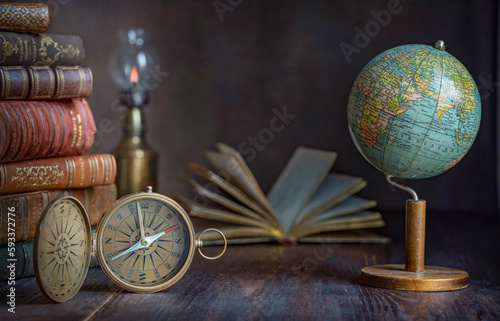 Old earth globe  compass  books on the table. In the cabinet of a traveler  explorer  investigator  discoverer. Concept on the theme of travel  world exploration  earth day  antiquity  history. 