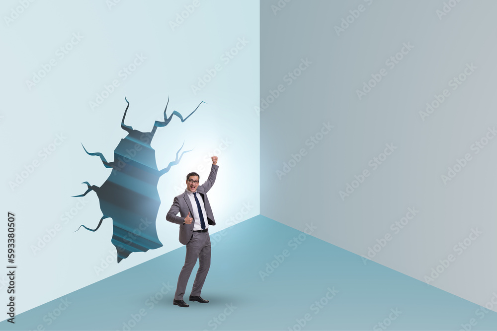 Fototapeta premium Businessman breaking through the wall