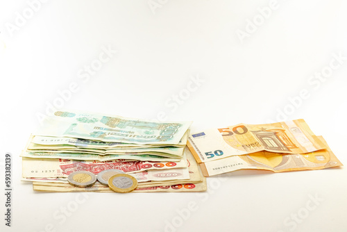 Two fifty Euros bill, six bills of one thousand and five bills of two thousand Algerian dinars with three coins of two hundred, one hundred and fifty dinars.  Overhead view on white background