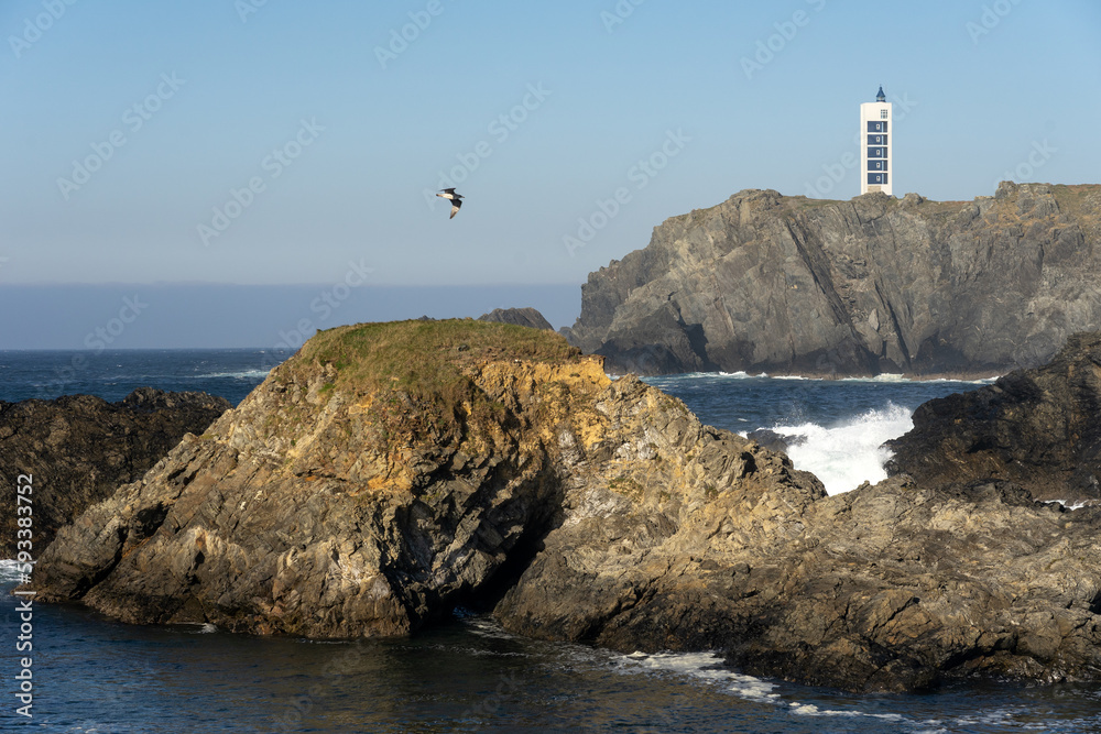 Punta Frouxeira lighthouse with the cliffs in the Rias Altas touristic area of Galicia at sunset, Valdoviño, Meiras, Spain.