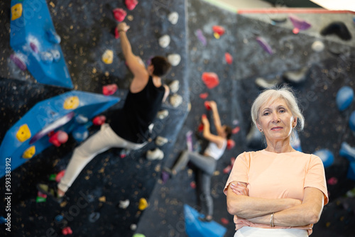 Senior female climber getting ready to climb wall in gym