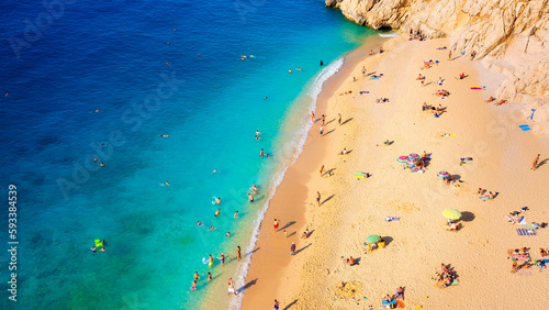 Fototapeta Naklejka Na Ścianę i Meble -  Aerial view on beach and umbrellas. Sumer vacation and adventure. Beach and blue water. Top view from drone at beach and azure sea.