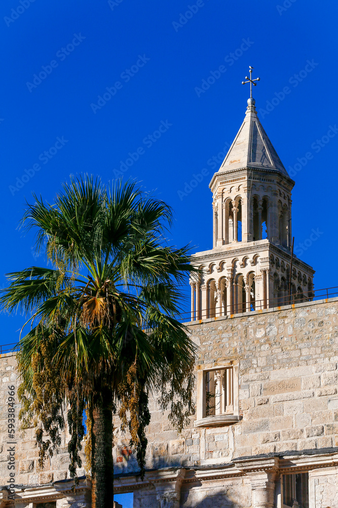 Bell tower of St Domnius cathedral inside Diocletian's palace with palm trees in front
