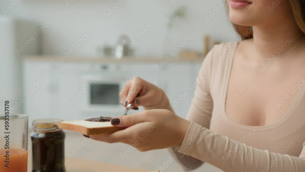 Close up Asian woman spread chocolate paste on bread with knife chinese korean japanese housewife girl put on toast nut creamy butter cooking breakfast nutrition order food delivery from supermarket