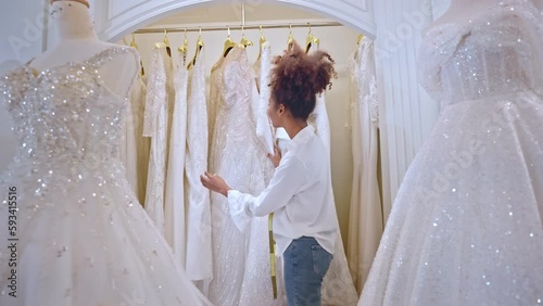 African American female designer designing bridal gown in wedding studio. 