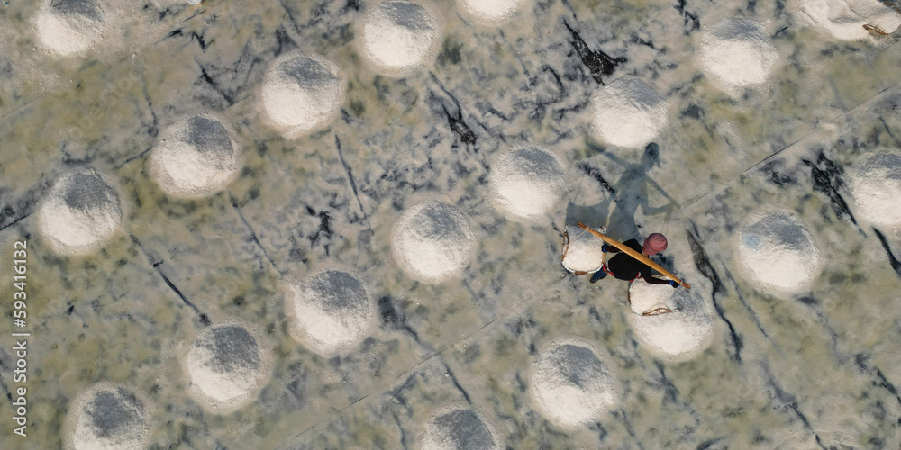Aerial view of worker harvesting salt in salt field at Ban Laem-Thailand Aerial view of worker harvesting salt in salt field at Ban Laem-Thailand