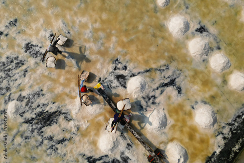  Aerial view of worker harvesting salt in salt field at Ban Laem-Thailand	