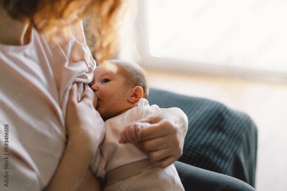 Newborn baby girl sucking milk from mothers breast. Portrait of mom and breastfeeding baby