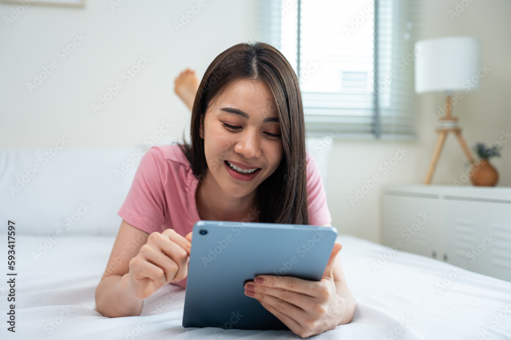 Asian attractive woman using tablet chat on bed at home in the morning. Asian attractive woman using tablet chat on bed at home in the morning.