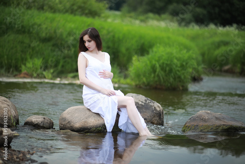 Pregnant woman in nature for a walk in the summer