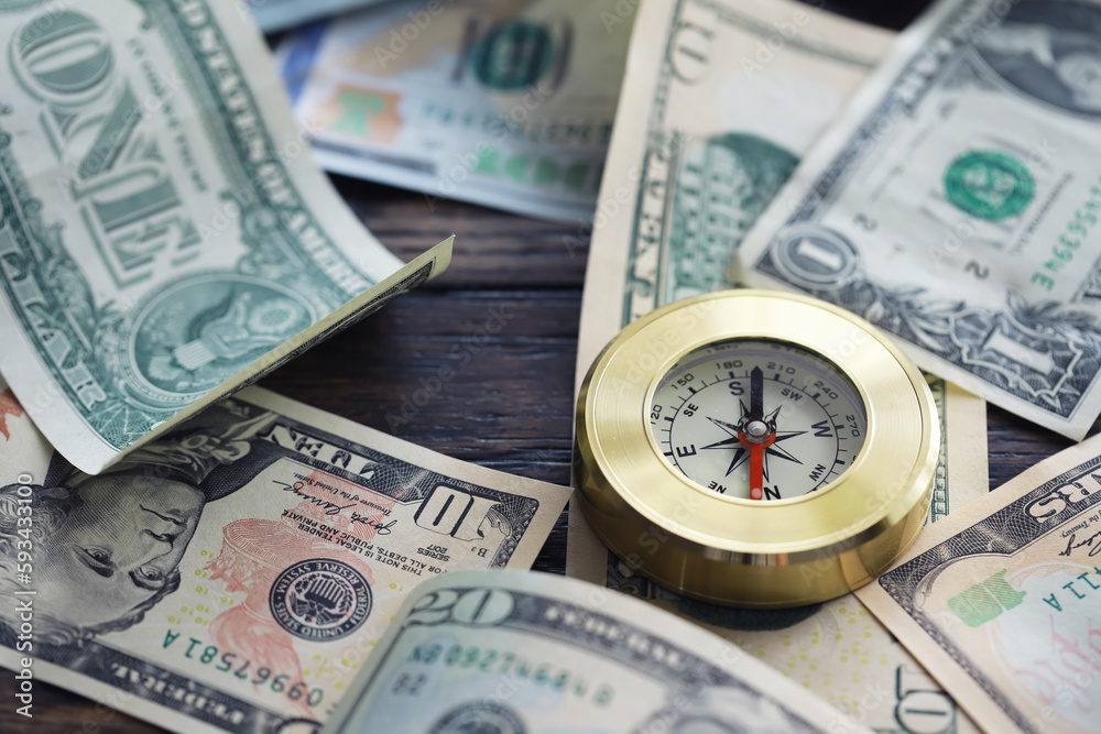 Money bill with golden Compass. Bullets and cartridge cases as a military concept. Close up US Currency and compass. business, financial idea, concept, symbol of crisis, inflation Money bill with golden Compass. Bullets and cartridge cases as a military concept. Close up US Currency and compass. business, financial idea, concept, symbol of crisis, inflation