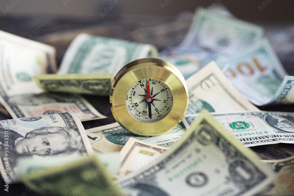 Money bill with golden Compass. Bullets and cartridge cases as a military concept. Close up US Currency and compass. business, financial idea, concept, symbol of crisis, inflation Money bill with golden Compass. Bullets and cartridge cases as a military concept. Close up US Currency and compass. business, financial idea, concept, symbol of crisis, inflation
