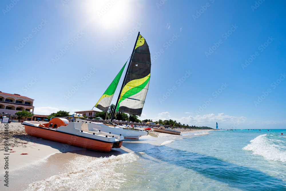 Fototapeta premium sailing catamaran is parked on the white sand on the seashore against the backdrop of beautiful tropical nature. tourist attractions in Cuba.