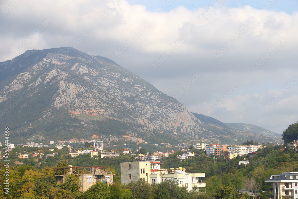 View of the highway, houses and mountains in Alanya, orange groves. Evening time, Turkiye, April 2023