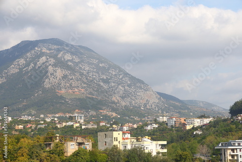 View of the highway, houses and mountains in Alanya, orange groves. Evening time, Turkiye, April 2023 © Aleksandr