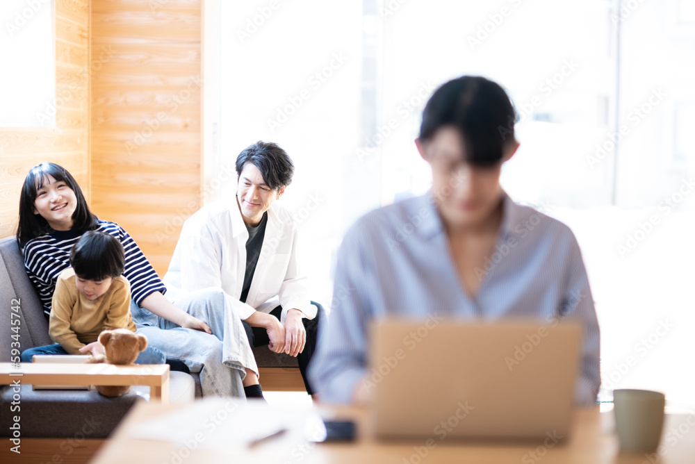 くつろぐ家族と仕事をする女性 くつろぐ家族と仕事をする女性