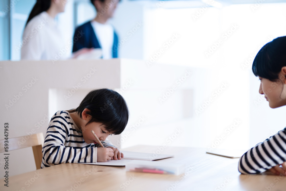 Obraz premium 勉強をする子供とキッチンで話す夫婦