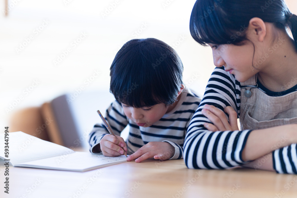 宿題をする男の子と見守る姉 宿題をする男の子と見守る姉