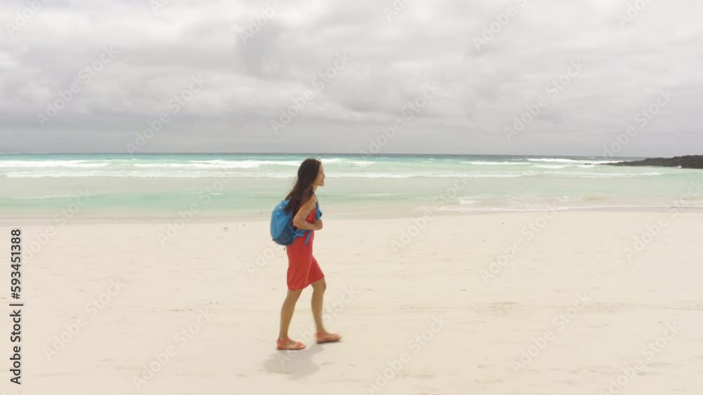 Galapagos tourist walking on Tortuga Bay beach in Santa Cruz island. Galapagos islands Galapagos tourist walking on Tortuga Bay beach in Santa Cruz island. Galapagos islands