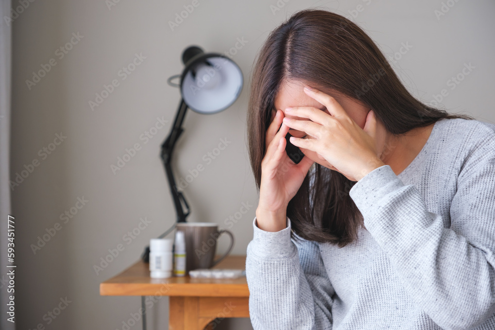 A young woman feeling sad and stressed, sick and headache at home