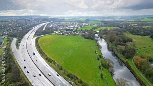 Aerial drone cinematic video footage of the M1 Motorway near the city of Wakefield, West Yorkshire, UK. Showing the busy motorway full of traffic and commercial buildings. photo