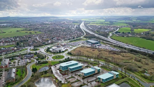 Aerial drone cinematic video footage of the M1 Motorway near the city of Wakefield, West Yorkshire, UK. Showing the busy motorway full of traffic and commercial buildings. photo