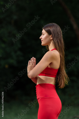 Young attractive calm brunette enjoying relaxing yoga meditation outdoor