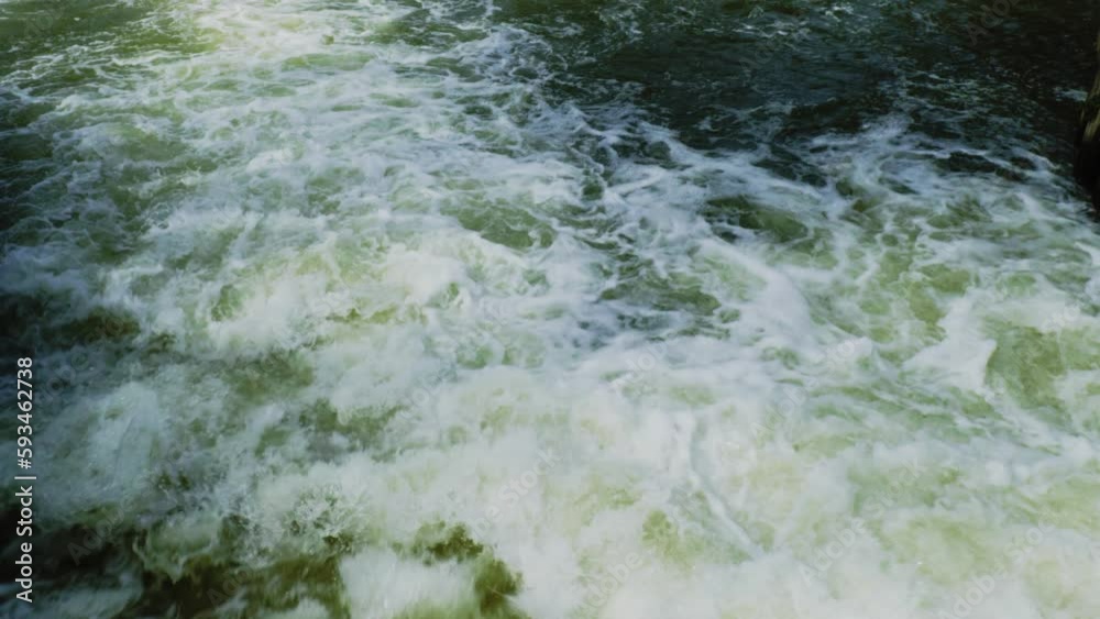 Roaring rough white water moves quickly in a busy river