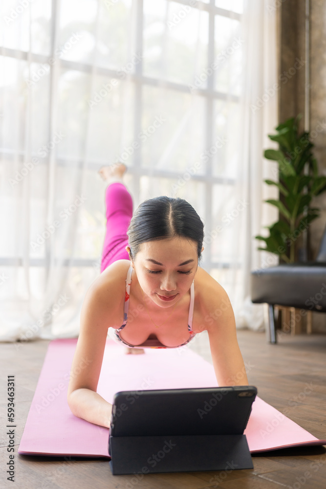 Young Asian woman doing yoga stretches at home. Happy people at home doing aerobic exercise at living room. exercise for health at home Young Asian woman doing yoga stretches at home. Happy people at home doing aerobic exercise at living room. exercise for health at home