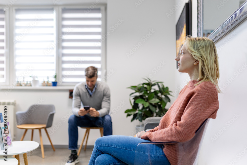 People, man and woman sitting in a queue, and waiting for a doctor's appointment in the hospital. Waiting room concept. People, man and woman sitting in a queue, and waiting for a doctor's appointment in the hospital. Waiting room concept.