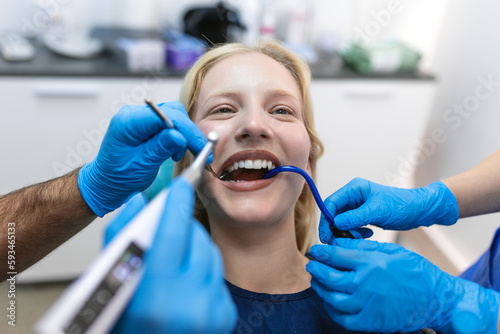 Teeth health concept. Cropped photo of smiling woman mouth under treatment at dental clinic  panorama