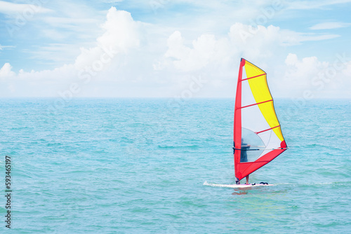 Man on a water sailing windsurfing board at sea. Fun in the ocean, extreme sport.