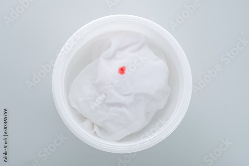 Soaking clothes  with a blood stain in a white basin. Use cold water. top view. daily life stain concept