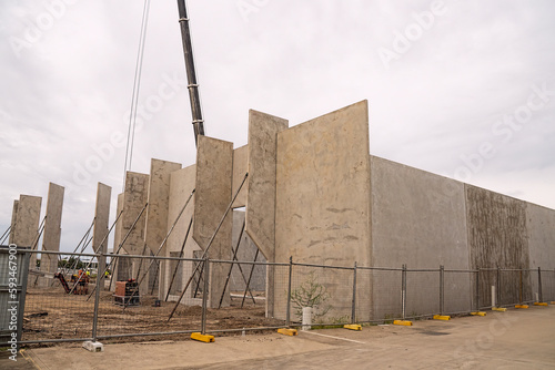 Workmen completing the foundations of a tilt-up warehouse being constructed of prefabricated concrete panels..