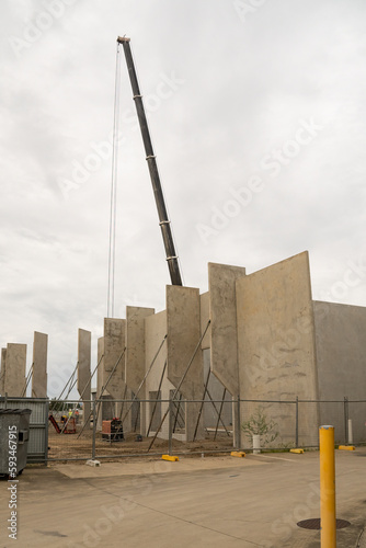 Workmen completing the foundations of a tilt-up warehouse being constructed of prefabricated concrete panels.