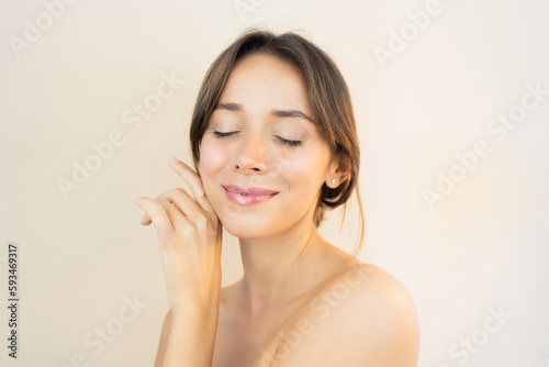 Billede på lærred Young Smiling Woman With Glowy Skin Eyes Closed Touching her Face with Flawless