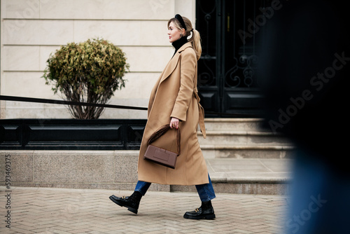 Cuadro en lienzo Side view beautiful woman walking street in fashionable spring or autumn clothes cashmere coat, jeans, loafers shoes and small bag