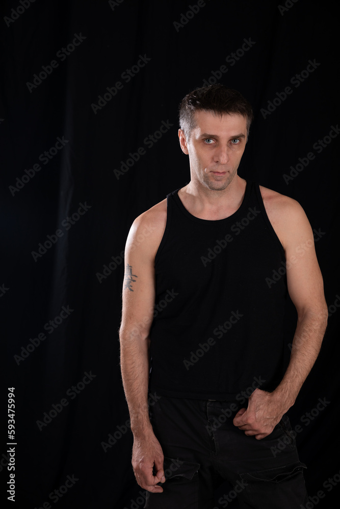 a man posing on a black background in a dark room a man posing on a black background in a dark room