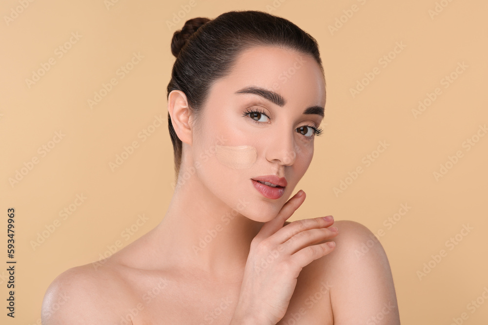 Woman with swatch of foundation on face against beige background Woman with swatch of foundation on face against beige background