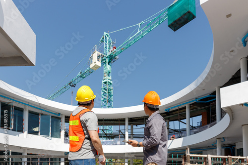 Construction concept of Engineer and Architect working with construction model and blueprint at construction site, Engineer and Architect discussing construction plan at building site