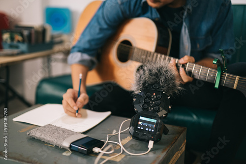 Close up of music recorder for creative musicians. Artist composer in work process, songwriter thinking and writing notes, man playing live acoustic guitar.concept for musician creative.