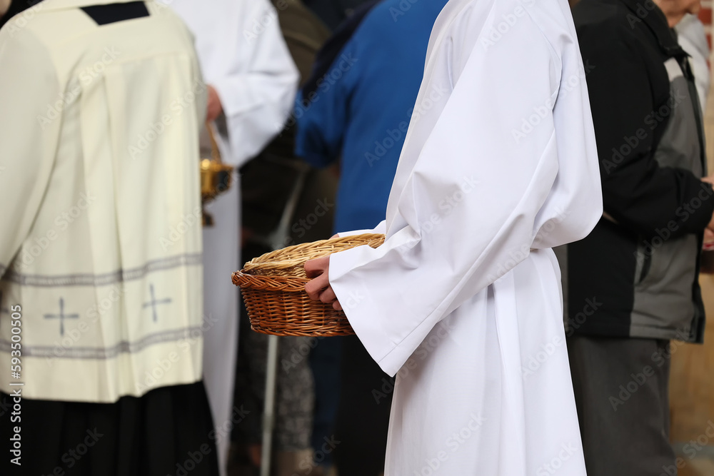 Obraz na płótnie Ministrant zbiera datki do koszyka od wiernych w kościele katolickim. Ofiara.  w salonie