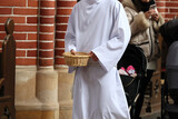 Ministrant zbiera datki do koszyka od wiernych w kościele katolickim. Ofiara. 