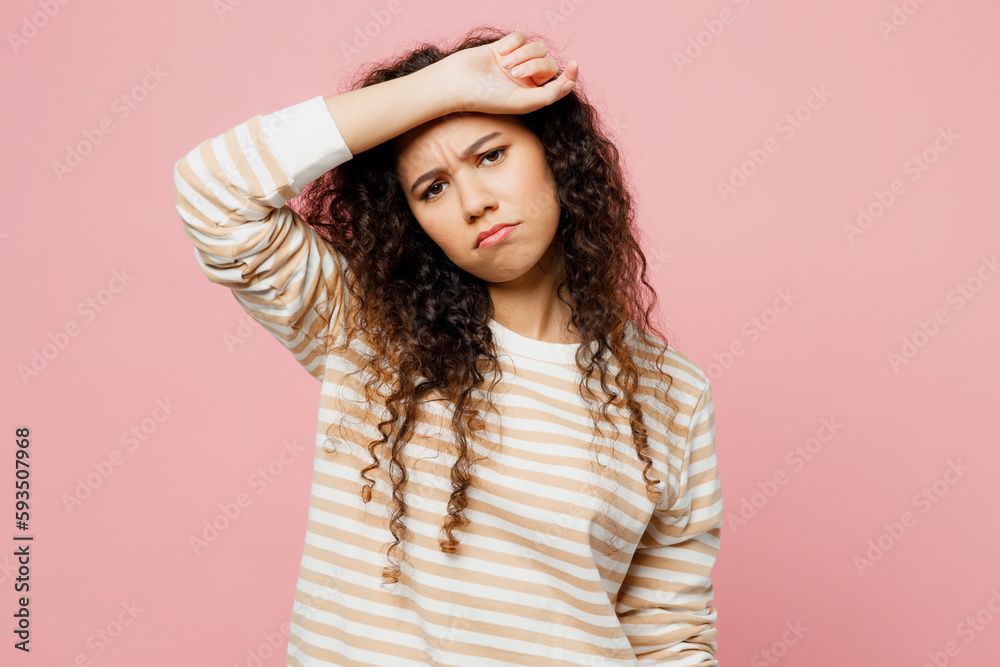 Young sad sick ill tired exhausted woman of African American ethnicity she wear light casual clothes put hand on forehead suffer from headache isolated on plain pastel pink background studio portrait. Young sad sick ill tired exhausted woman of African American ethnicity she wear light casual clothes put hand on forehead suffer from headache isolated on plain pastel pink background studio portrait.