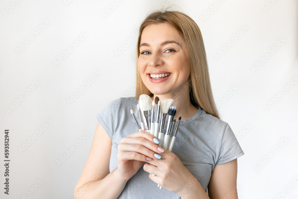Portrait of the beautiful woman with make-up brushes near attractive face with natural make up Portrait of the beautiful woman with make-up brushes near attractive face with natural make up