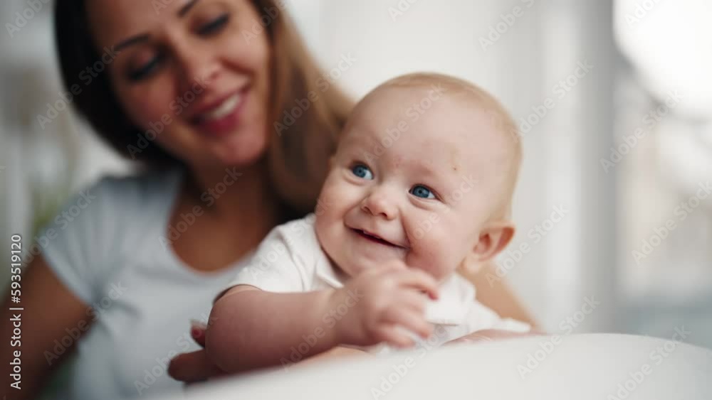 Happy mom babysitting little baby smiling talking at home in maternity leave. Motherhood babycare concept. Mother looking at her positive laughing kid. Babyhood, childhood, parenting, maternity leave. Happy mom babysitting little baby smiling talking at home in maternity leave. Motherhood babycare concept. Mother looking at her positive laughing kid. Babyhood, childhood, parenting, maternity leave.