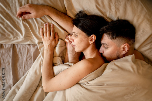 Man and woman snuggling in bed at home